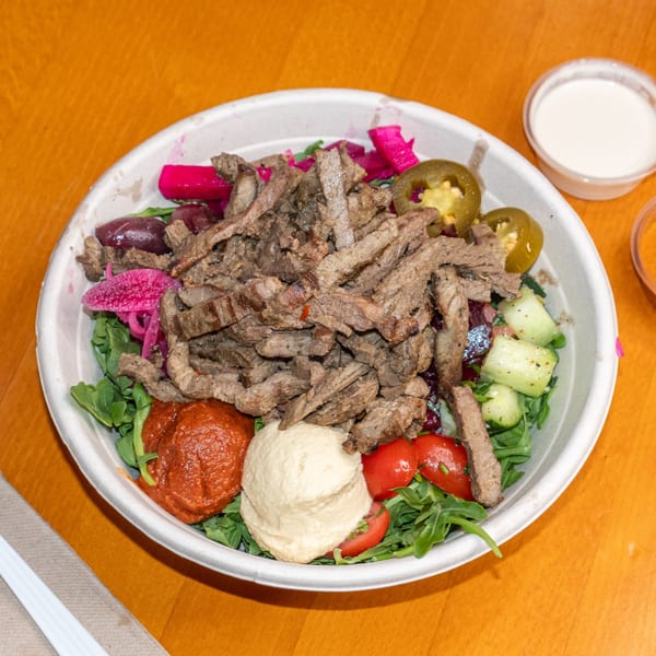 Falafel King's beef shawarma bowl with hummus, red sauce, pickled vegetables, and jalapeños.