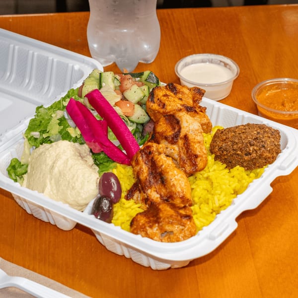 Falafel King's chicken shawarma plate with rice, hummus, salad, falafel, and pickled turnips.